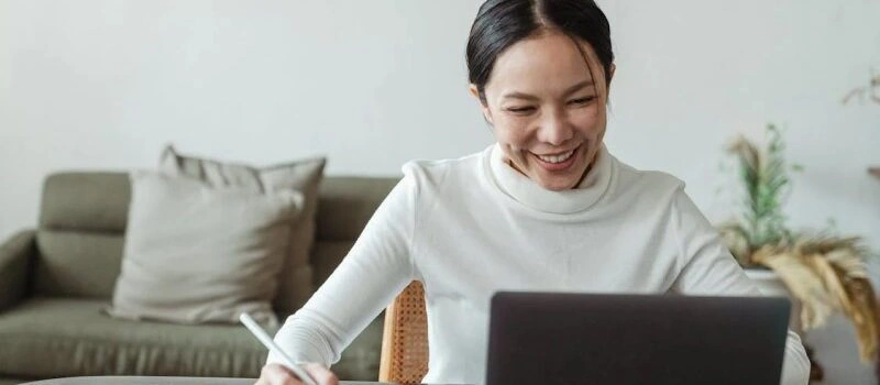 SEO Virtual Assistant for Your Business working on a laptop and taking notes