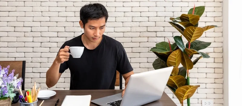 An SEO Expert Philippines with a laptop and coffee, surrounded by office supplies