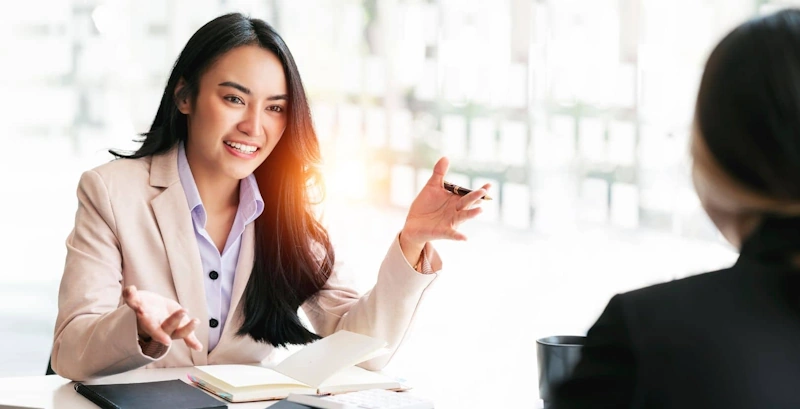 Two people talking at a table about how to Hire Virtual Assistant Philippines