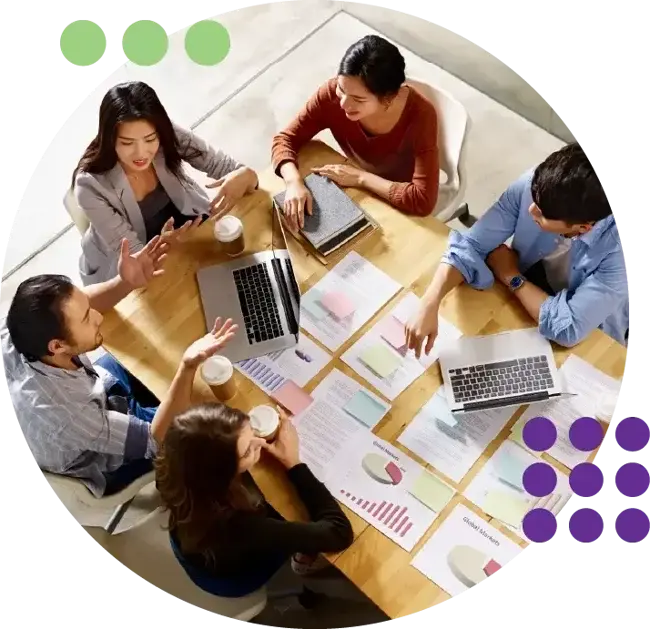 A professional team in the Philippines participating in an SEO training workshop around a table with data charts.